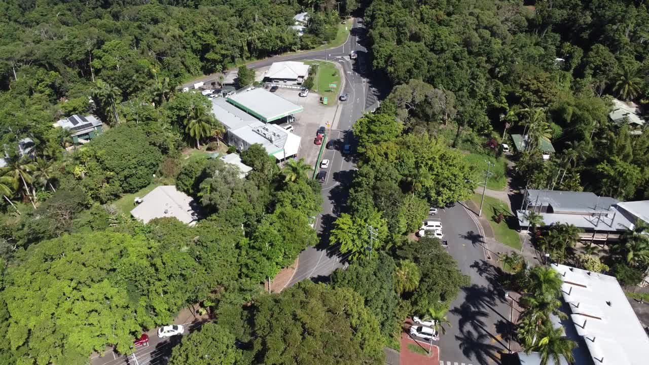 4K Aerial view of a gas station on a small mountain village in North Queensland, Australia surrounded by a tropical rainforest