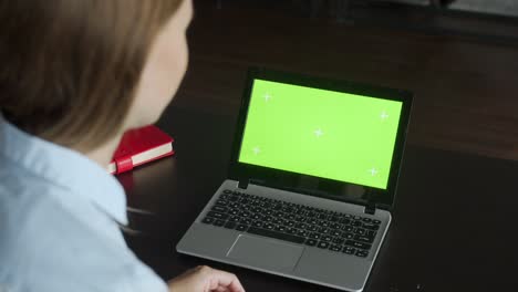 businesswoman video chatting online on laptop with green screen in office. corporate worker call video on laptop computer at home office