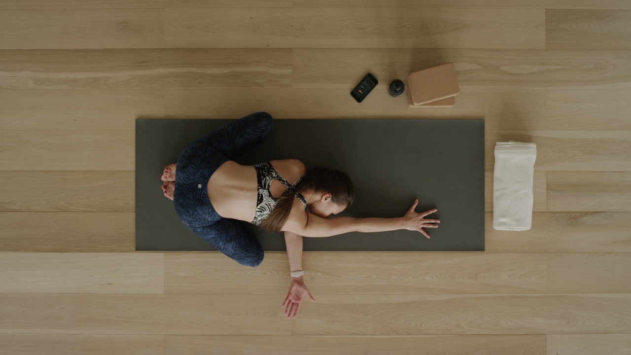 vista superior de una mujer de yoga practicando posturas en un estudio de entrenamiento disfrutando de un estilo de vida saludable practicando meditación en una colchoneta de ejercicios