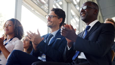 delegados en una conferencia de negocios aplaudiendo al orador