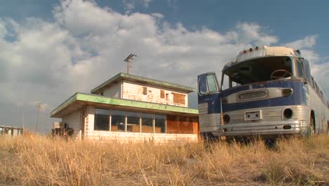 an abandoned greyhound bus in a field