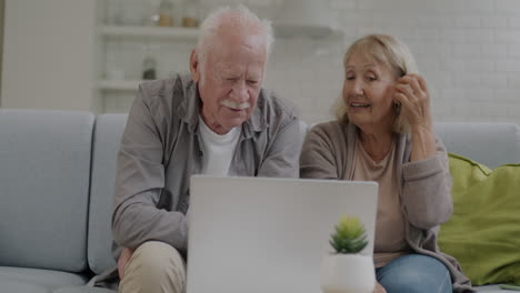 pareja de ancianos usando una computadora portátil en casa