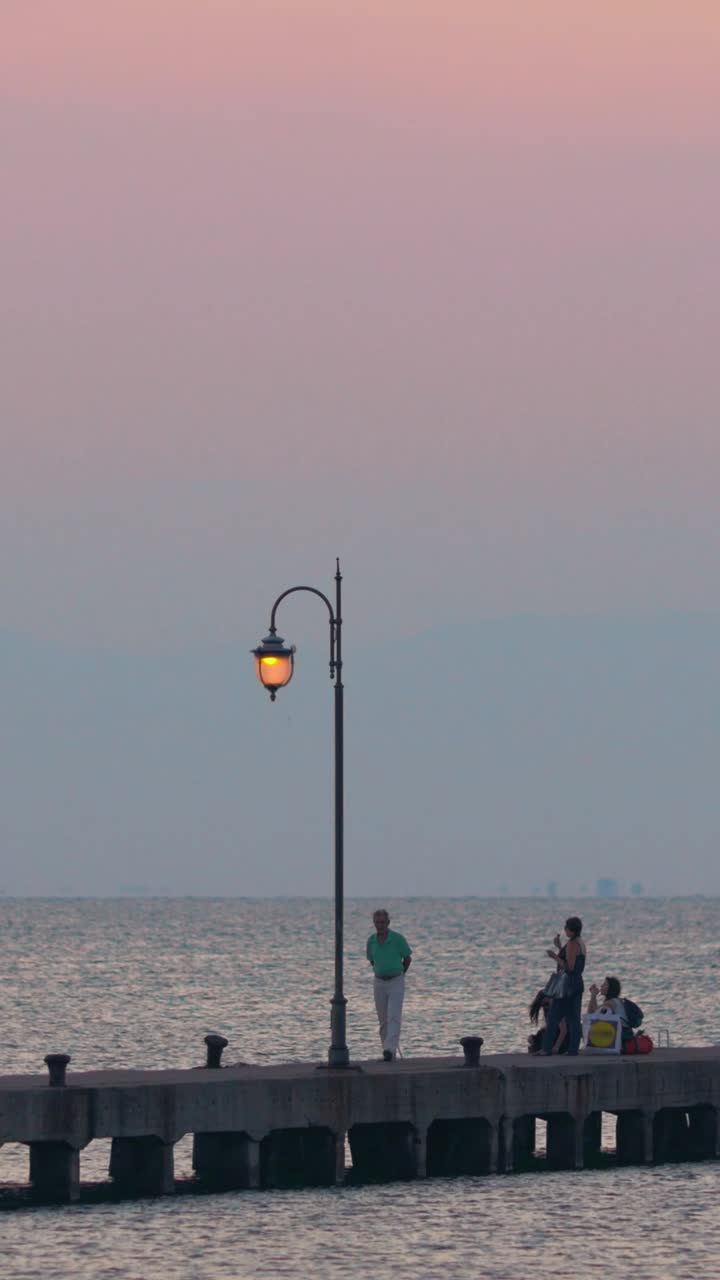 en un muelle al atardecer la gente