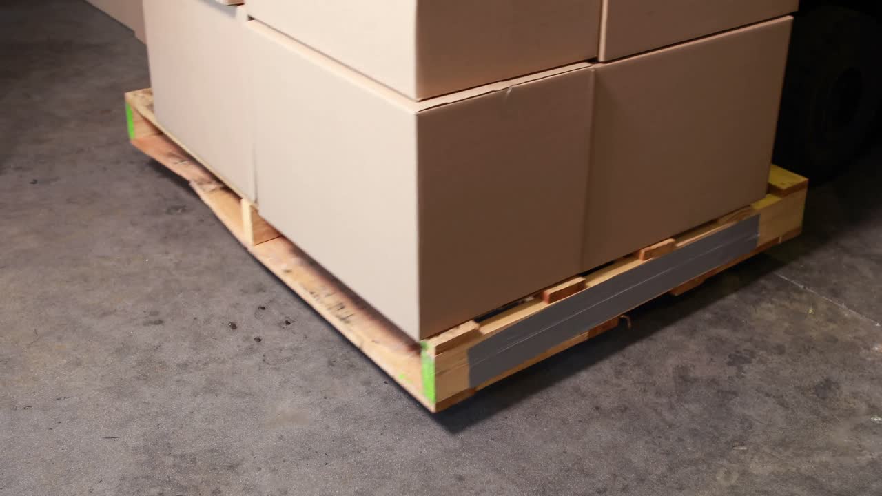 포크리프트가 상자 팔레트를 집어들고 있습니다.