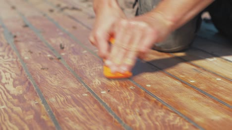 carpenter removing mastic excess using sharp scraper real time