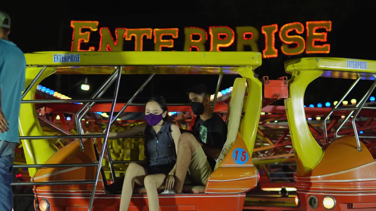 Two young people getting dizzy from a mechanical game
