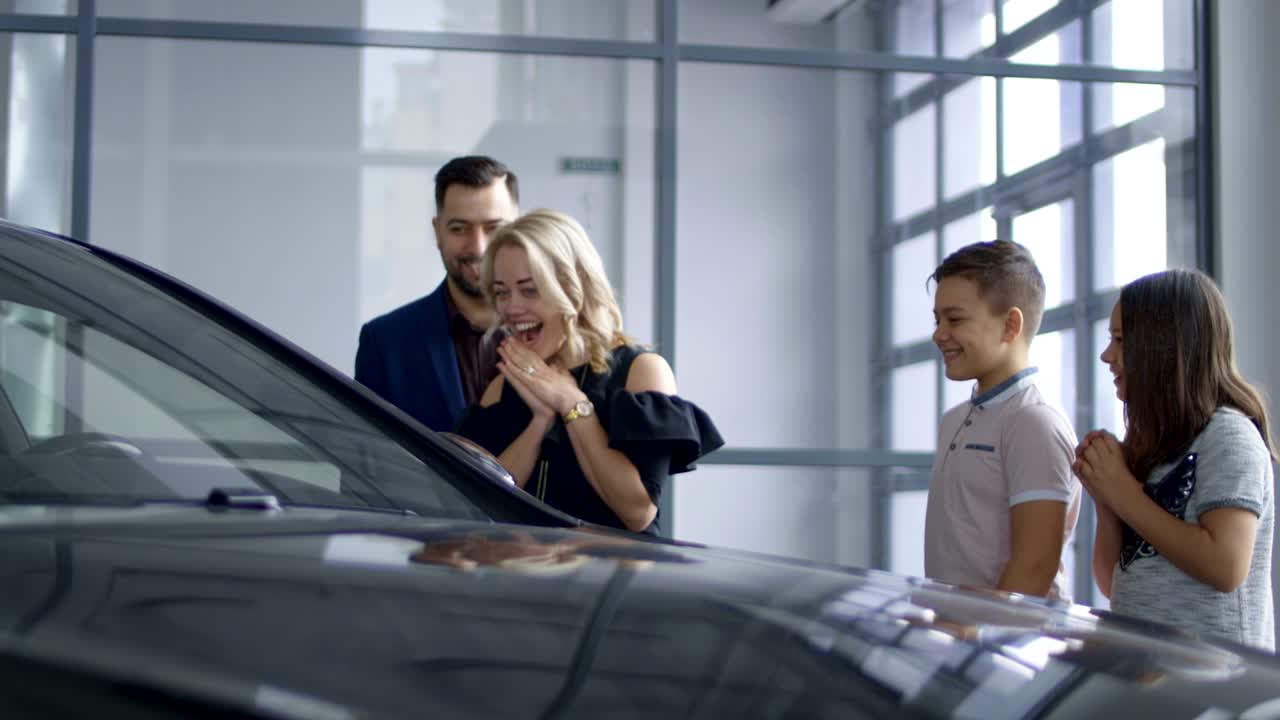 familia feliz consiguiendo un coche nuevo en el salón