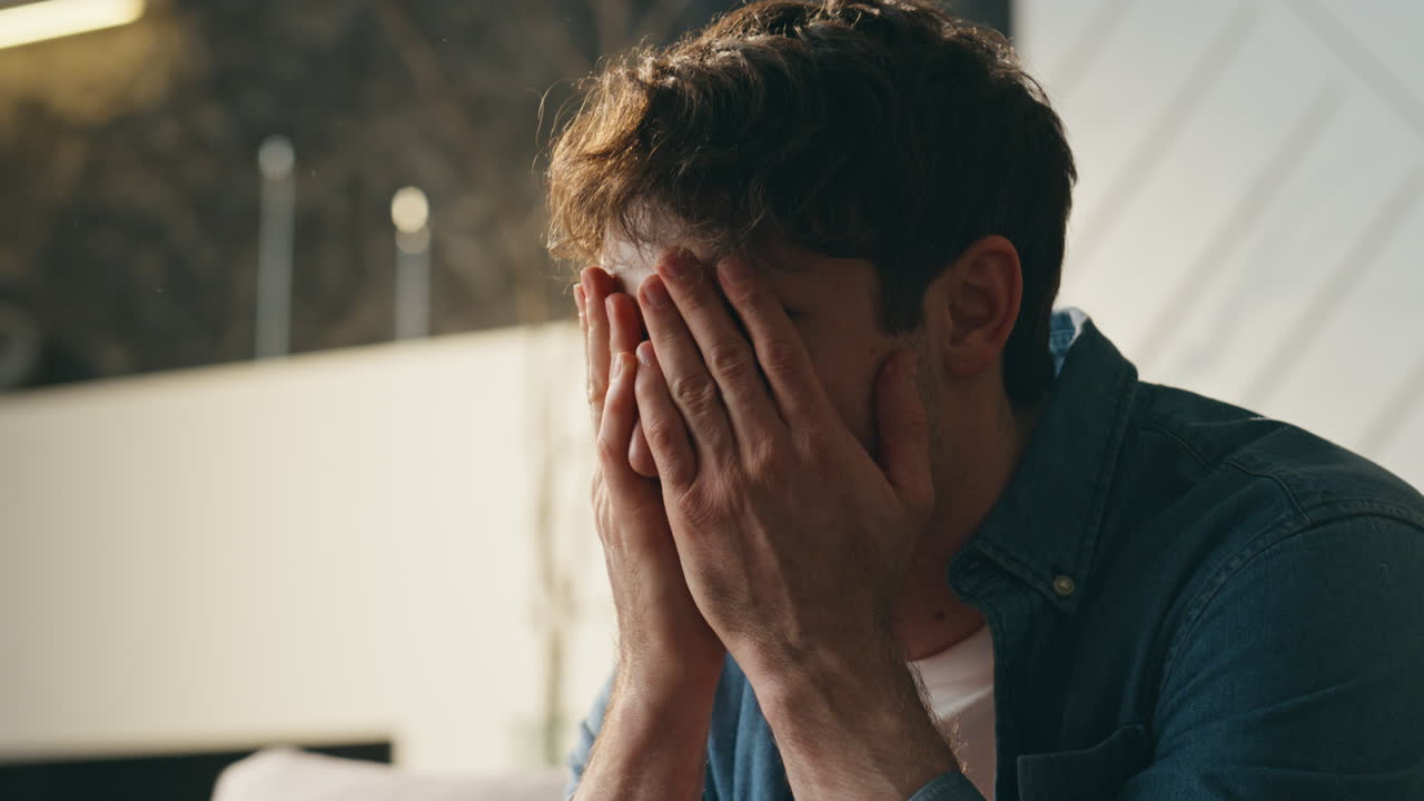 hombre agotado trabajando en casa sala de estar tarde en la noche cerca. trabajador independiente cansado