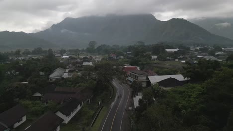 Misty-overcast-aerial-follows-moto-traffic-on-road-in-Sembalun-Lombok