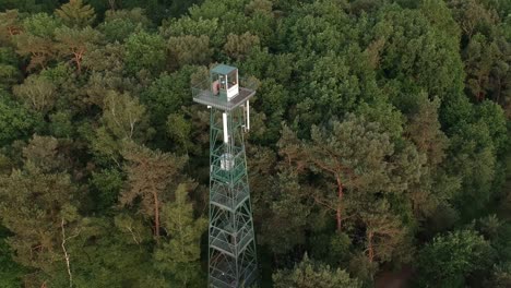 flying towards forest watchtower near dirt road, aerial view