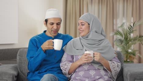 happy muslim couple drinking tea and enjoying