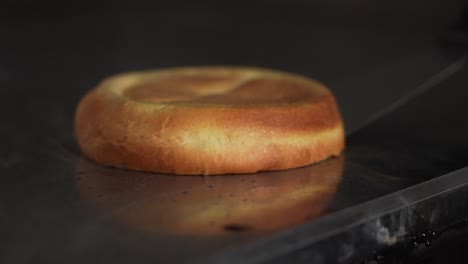 chef tostando un bollo de hamburguesa con mantequilla