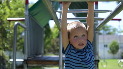 Zeitlupenaufnahme-Eines-Kleinen-Jungen,-Der-Auf-Den-Affenstangen-Auf-Einem-Spielplatz-In-Seinem-Hinterhof-Spielt-2