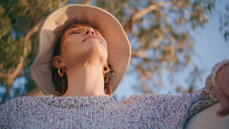 peaceful girl enjoy sunlight in summer garden closeup. calm woman closing eyes