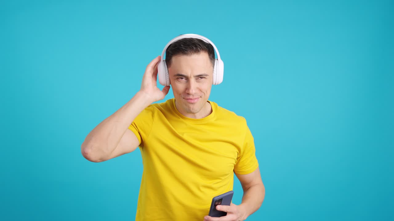 A man listening to music with headphones and using a smartphone