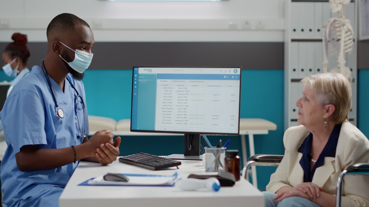 Medical professional consulting with elderly patient using electronic health records