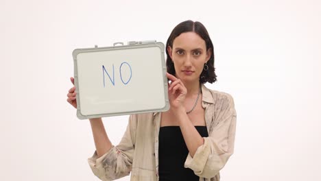 A woman holding a whiteboard with the word &#039;no&#039; written on it