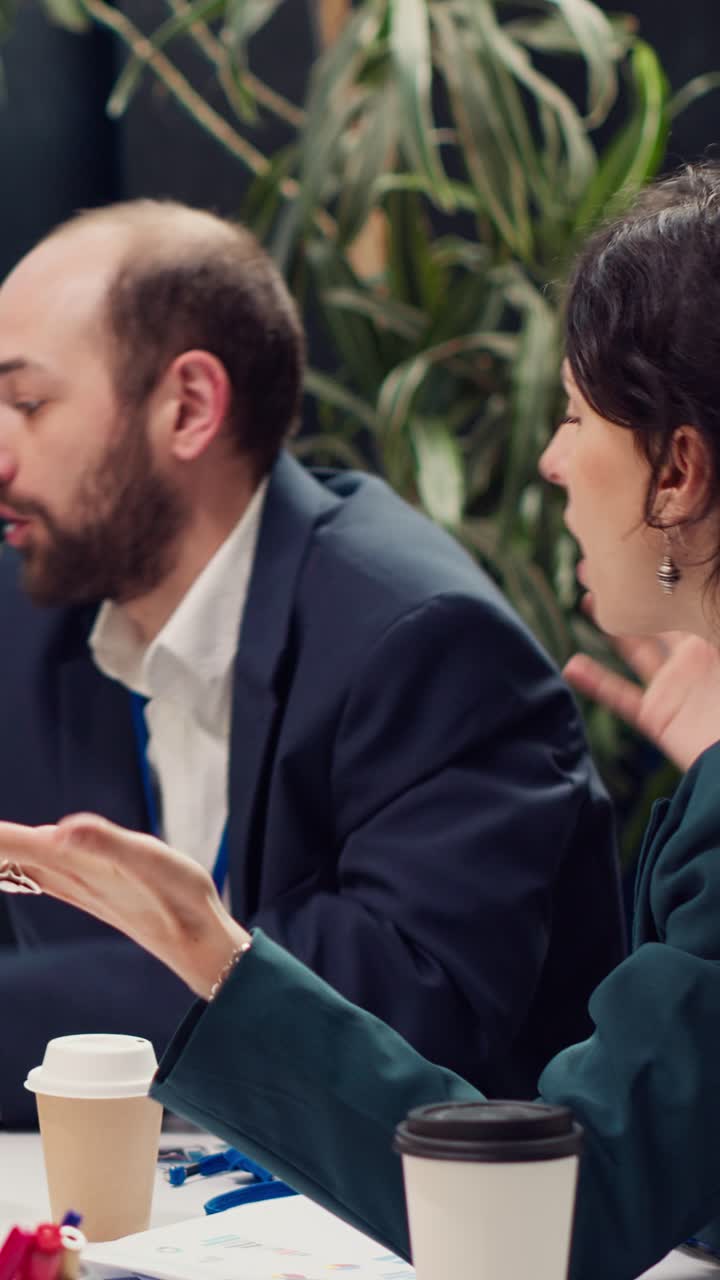 Forretningsfolk diskuterer dokumenter og gestikulerer under et møde på kontoret
