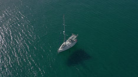 sailboat anchored on a sandbar in an area of ​​colorful water