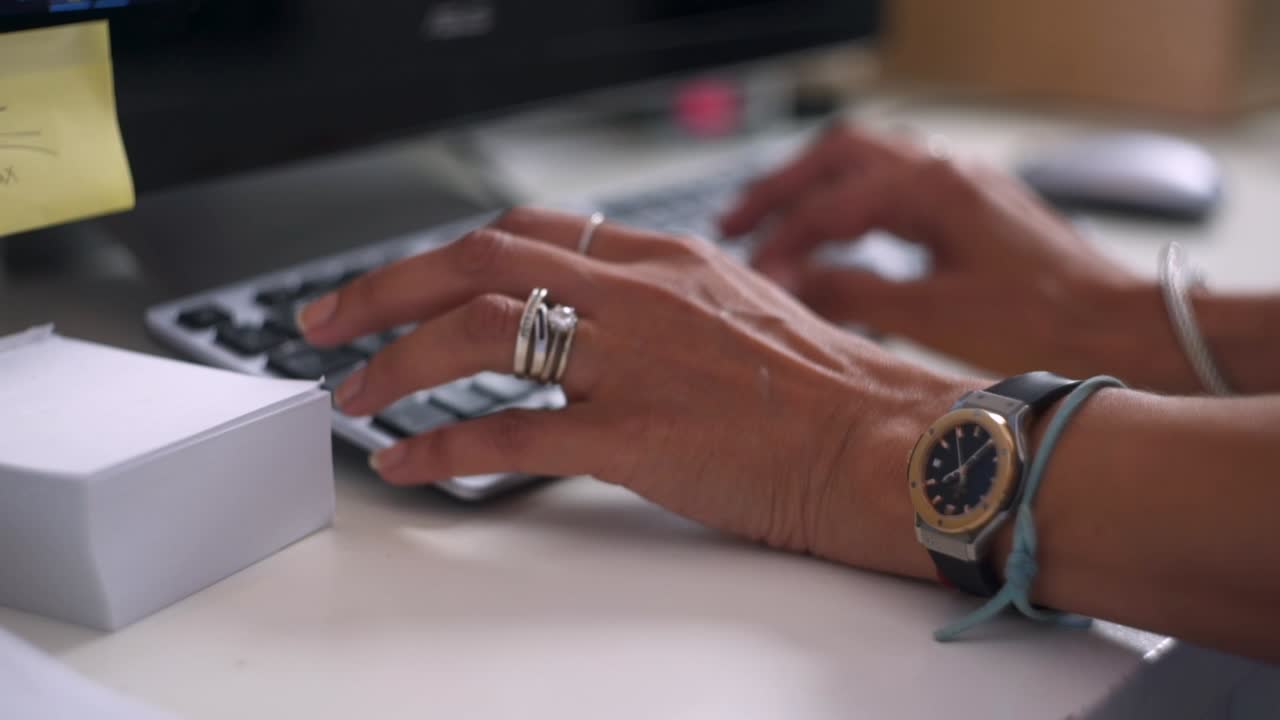 Waman hands typing on a keyboard