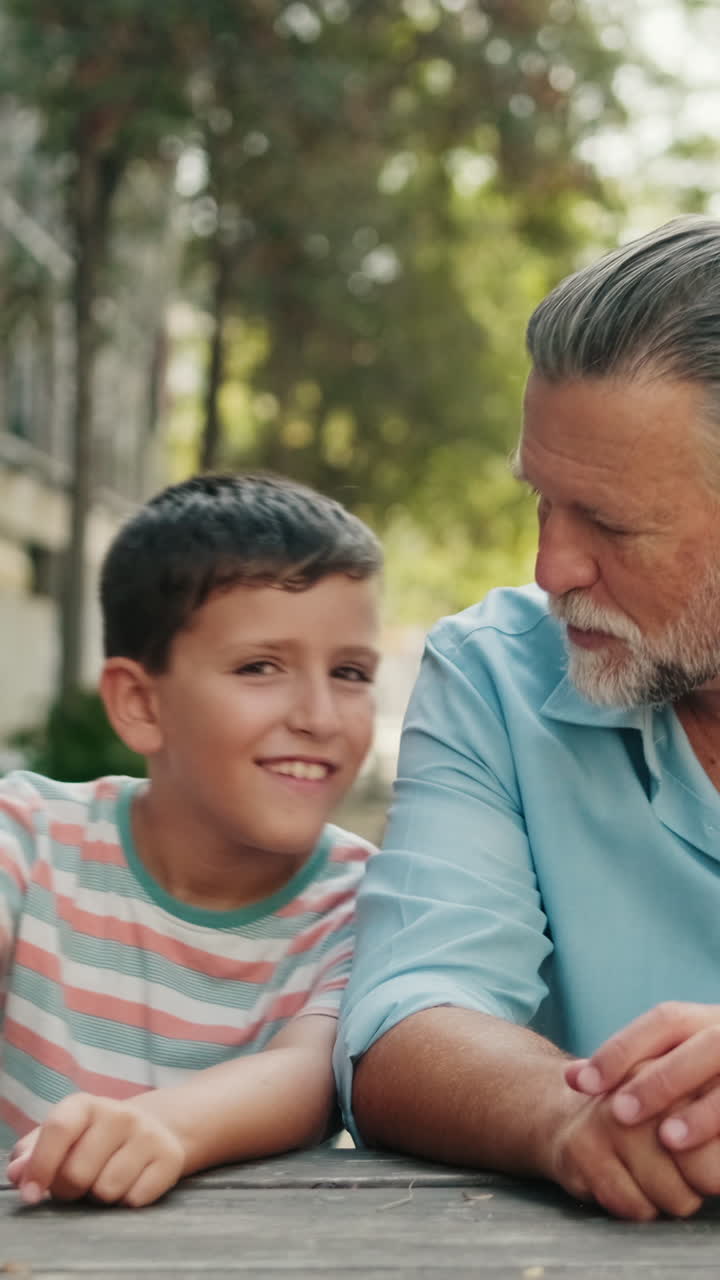 Abuelo y nieto hablando y riendo juntos al aire libre