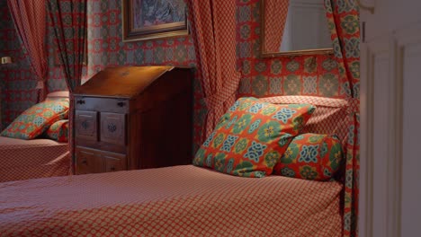 slow revealing shot of 2 single beds within a bedroom in the chateau de castille