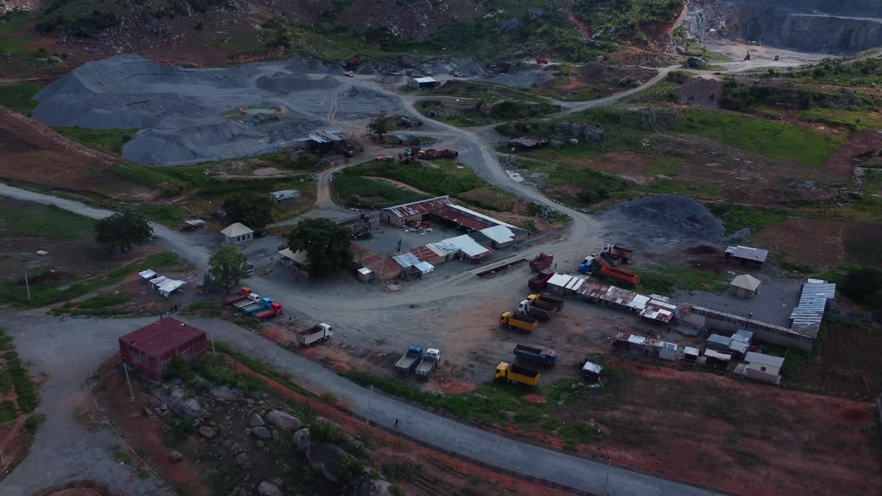 Drone video showcases expansive Abuja quarry with rugged terrain, vibrant earth hues, and machinery under twilight sky, capturing industrial ambiance and landscape beauty in Nigeria, Africa