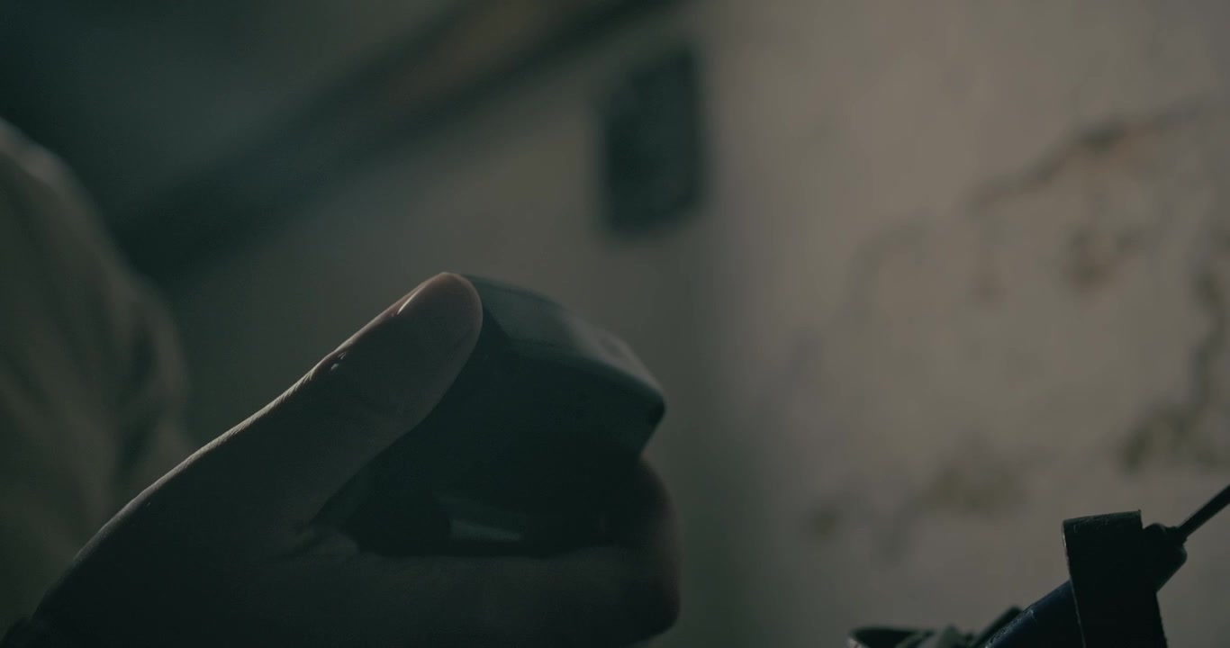 Un uomo usa un walkie-talkie retrò per comunicare all'interno di un bunker sotterraneo di guerra, creando una scena cinematografica con illuminazione suggestiva.