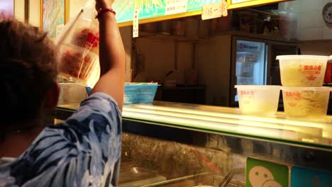 customer receives food from vendor at stall