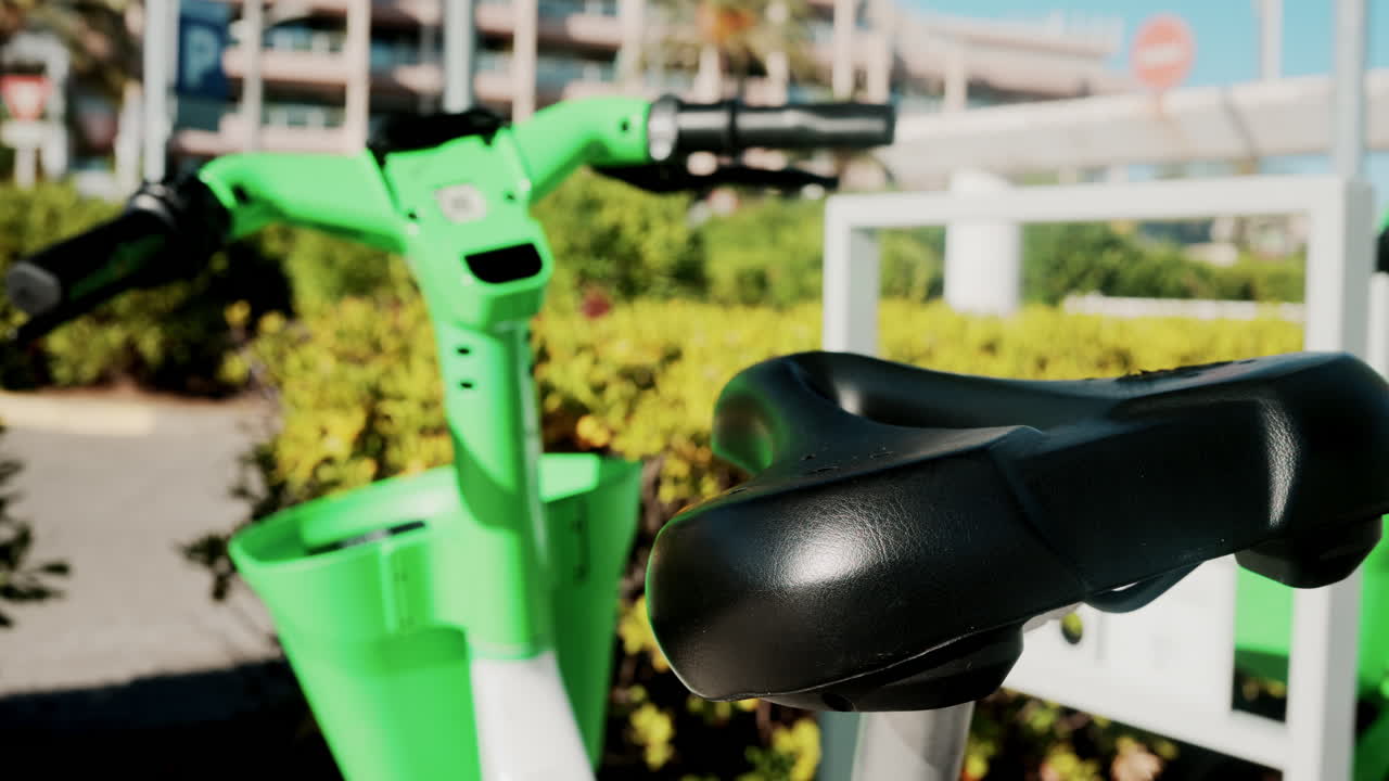 Close up of a green electric bicycle with modern design, parked outdoors under natural light