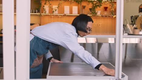 mesero limpiando mesa en cafetería