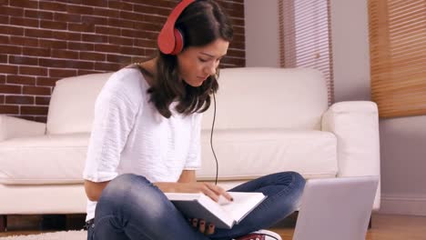mujer joven y bonita estudiando en el suelo
