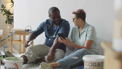 couple looking at smartphone during home renovation