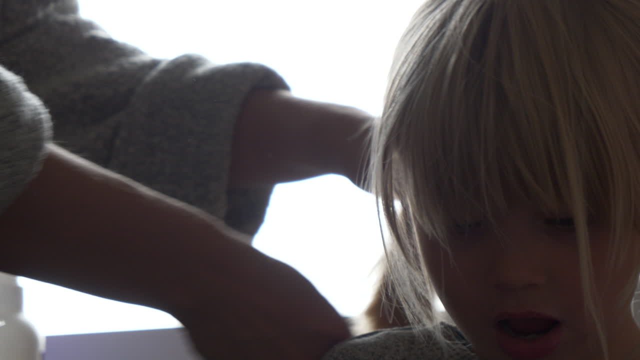 Getting ready for kindergarten daily routine, Mother Combing Hair of young girl
