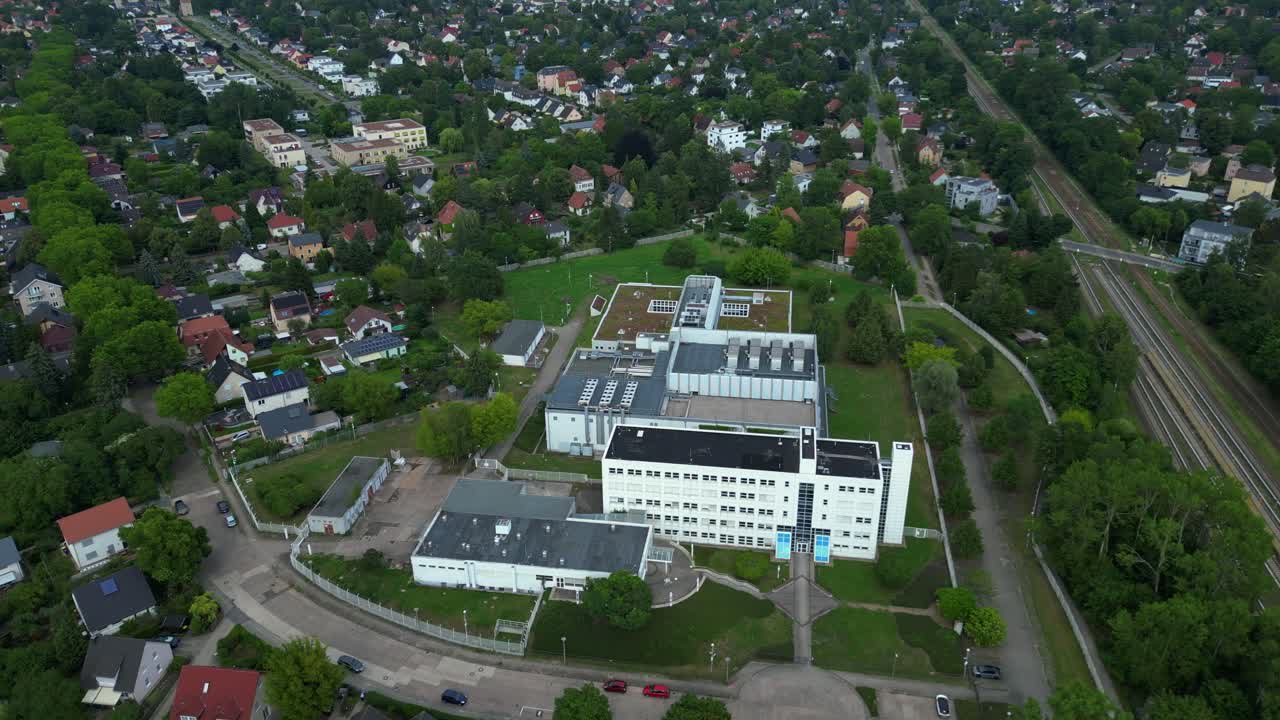 datacenter building with cooling system on the roof, surrounded by residential houses, showcasing urban and industrial integration. panorama orbit drone
