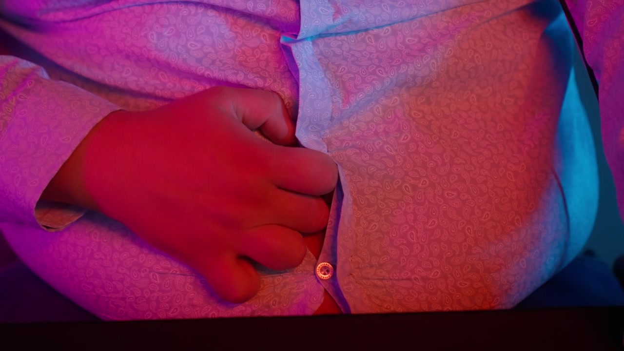 Close-up of a Person's Belly as Shirt Buttons Unfasten