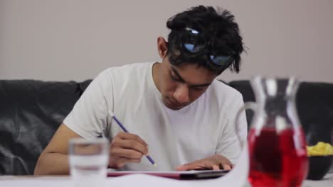 Front-view-of-young-male-student-fully-concentrate-on-study-at-home,-static