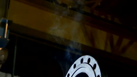 closeup light welding smoke lifts up over big metal pipe
