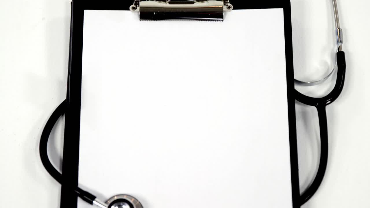 estetoscopio y clipboard con papel blanco en blanco