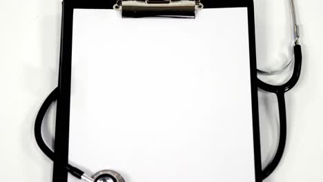 stethoscope and clipboard with white blank paper