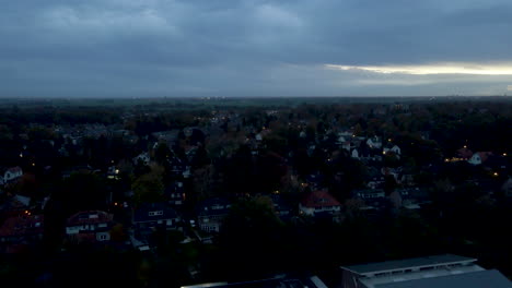 Fast-aerial-jib-up-of-suburban-town-in-the-early-morning-with-a-rising-sun-behind-the-clouds