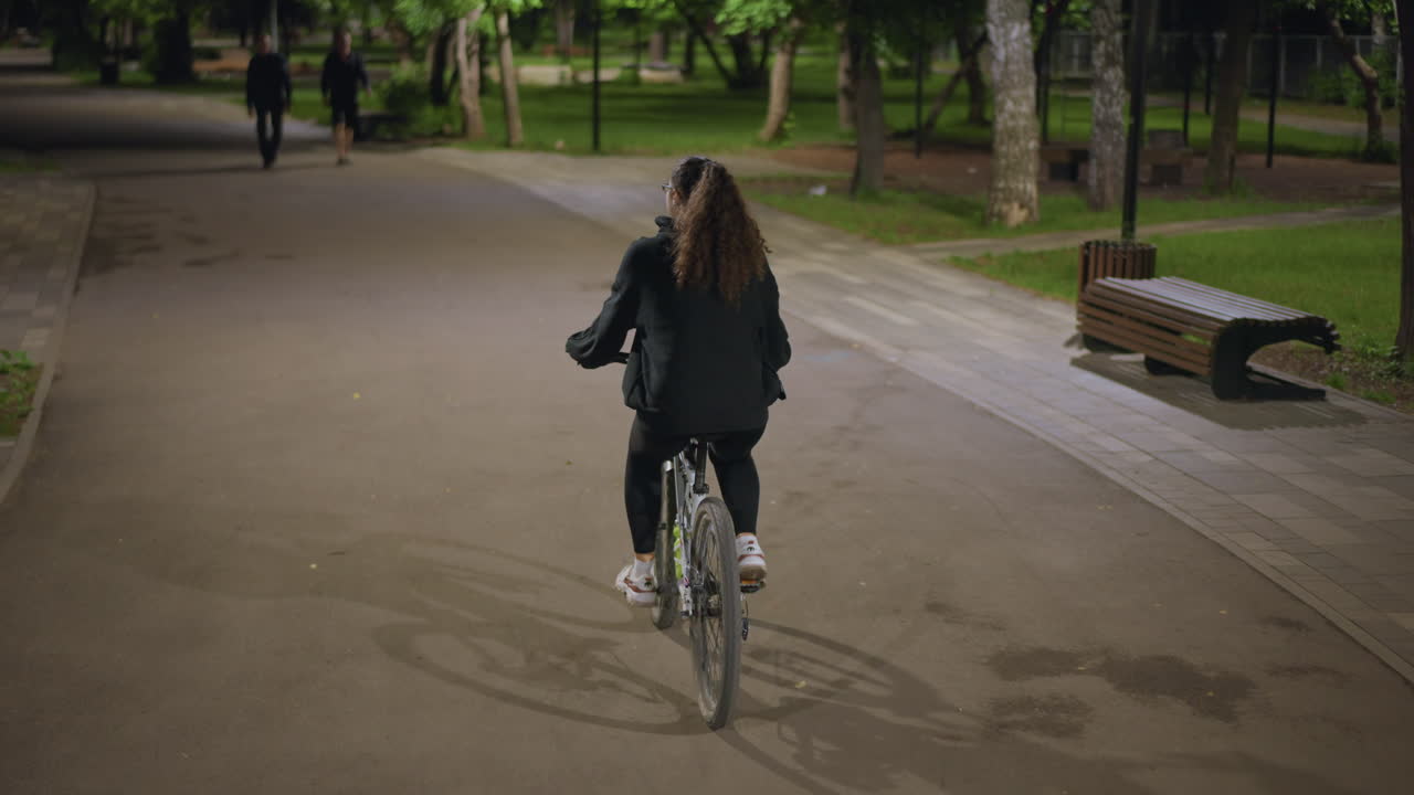 Cyclist Explores Quiet Park Under Dark Sky, Young Rider Experiences Peaceful And Solitary Nighttime Park Journey, Lone Cyclist Enjoys Calm And Tranquil Ride Through Silent Park At Night