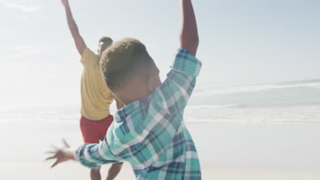 Padre-E-Hijo-Afroamericanos-Con-Los-Brazos-Abiertos-Disfrutando-En-La-Playa