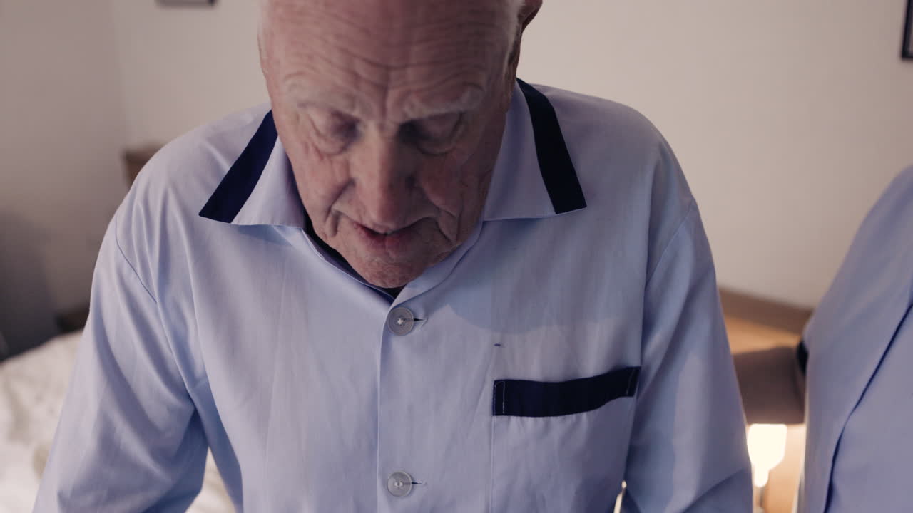 Elderly man receiving assistance from caregiver