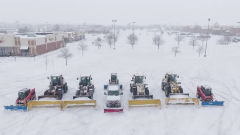front view of different types of snow removal vehicles on snow covered roads during blizzard. aerial shot.