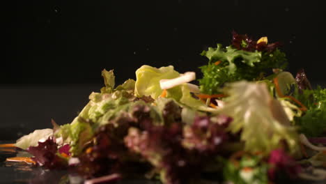 salad falling onto black surface