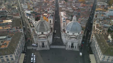 Birds-Eye-View-Above-Domes-of-Two-Twin-Churches-in-Piazza-del-Popolo,-Rome,-Italy