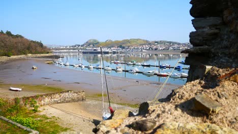 con vistas a los yates amarrados en la costa del puerto vista desde las ruinas de la pared de piedra con un cielo azul soleado