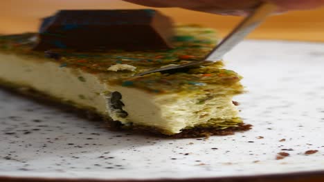 a piece of delicious pistachio cheesecake with chocolate topping