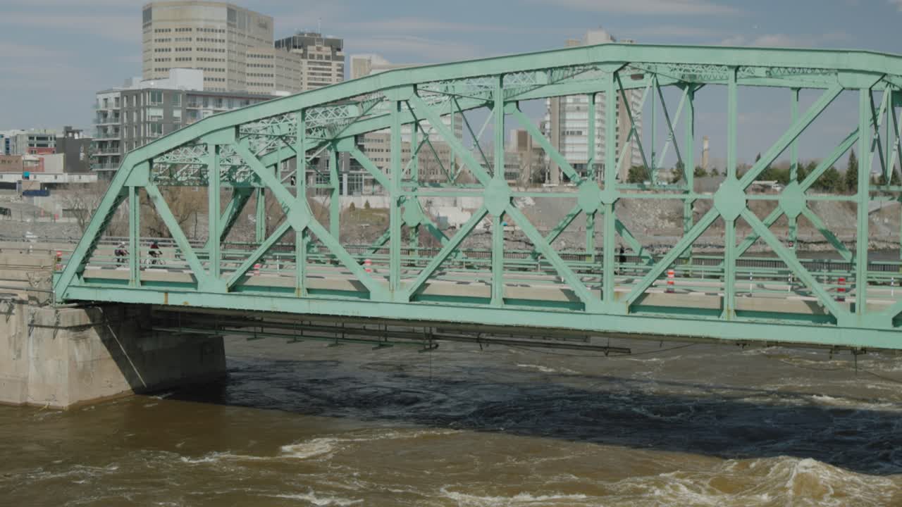 오타와 강을 가로지르는 초록색 쇼디에르 현수교를 건너는 보행자와 차량의 수력 전기 댐에서 촬영